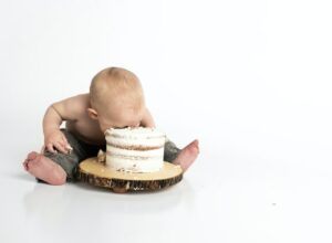 A baby with its face in a cake