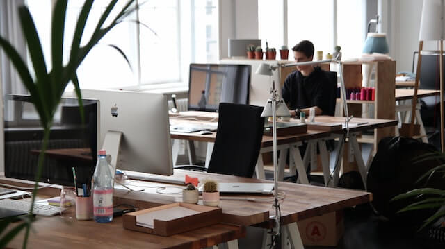 Office space with an employee working in the background